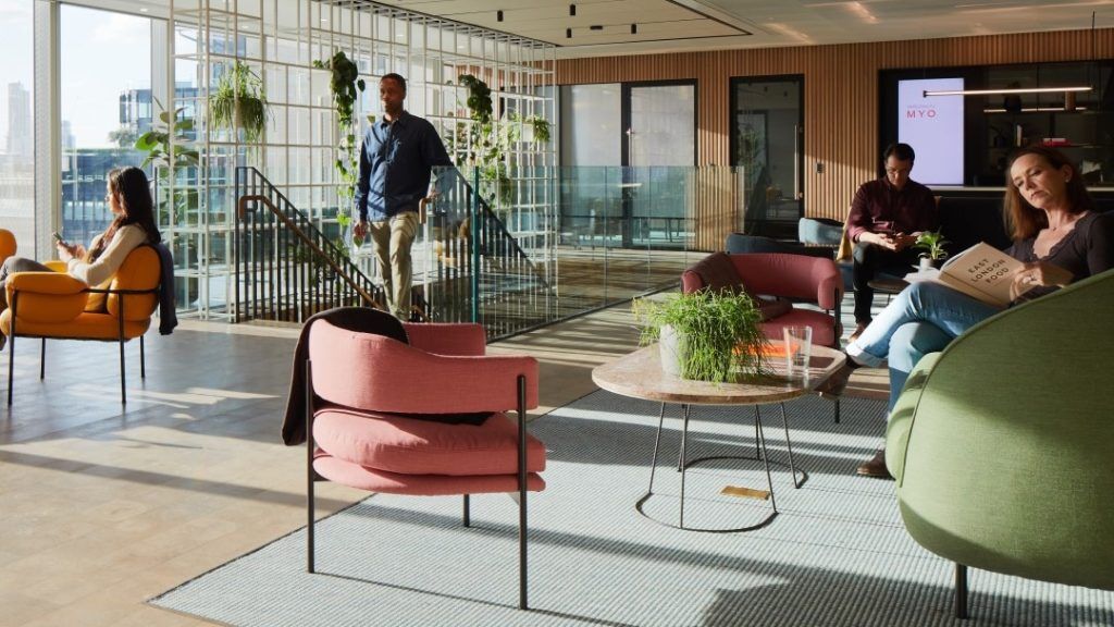 Myo Members work in the communal area at Myo Liverpool Street, featuring soft furnishings and breakout spaces.