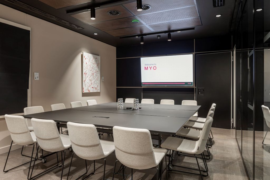 Myo Boardroom Balmond shown from the inside featuring a square table and 16 seats.