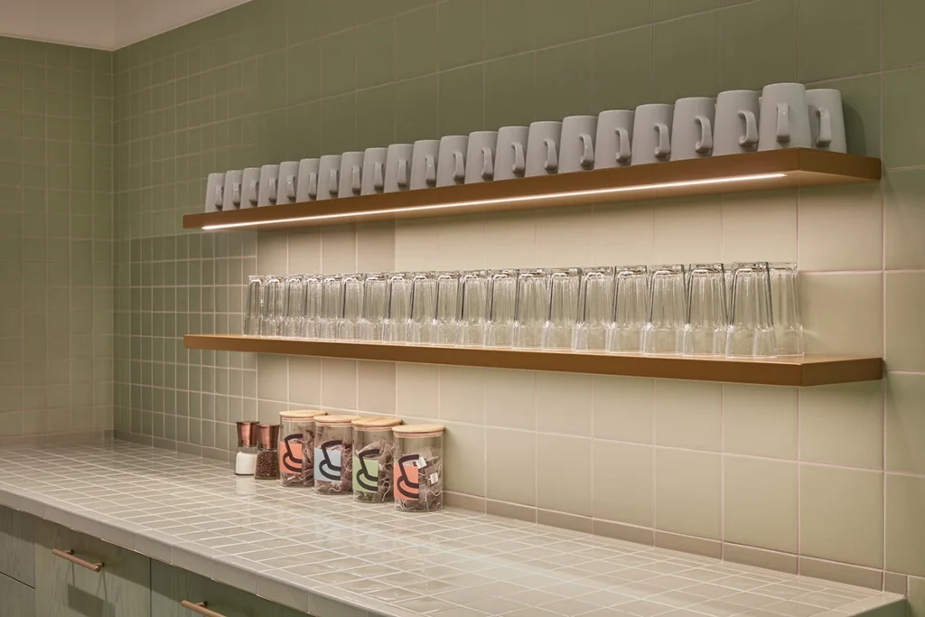  Lines of glasses and mugs in a clean office kitchen area at one of MYO's offices.
